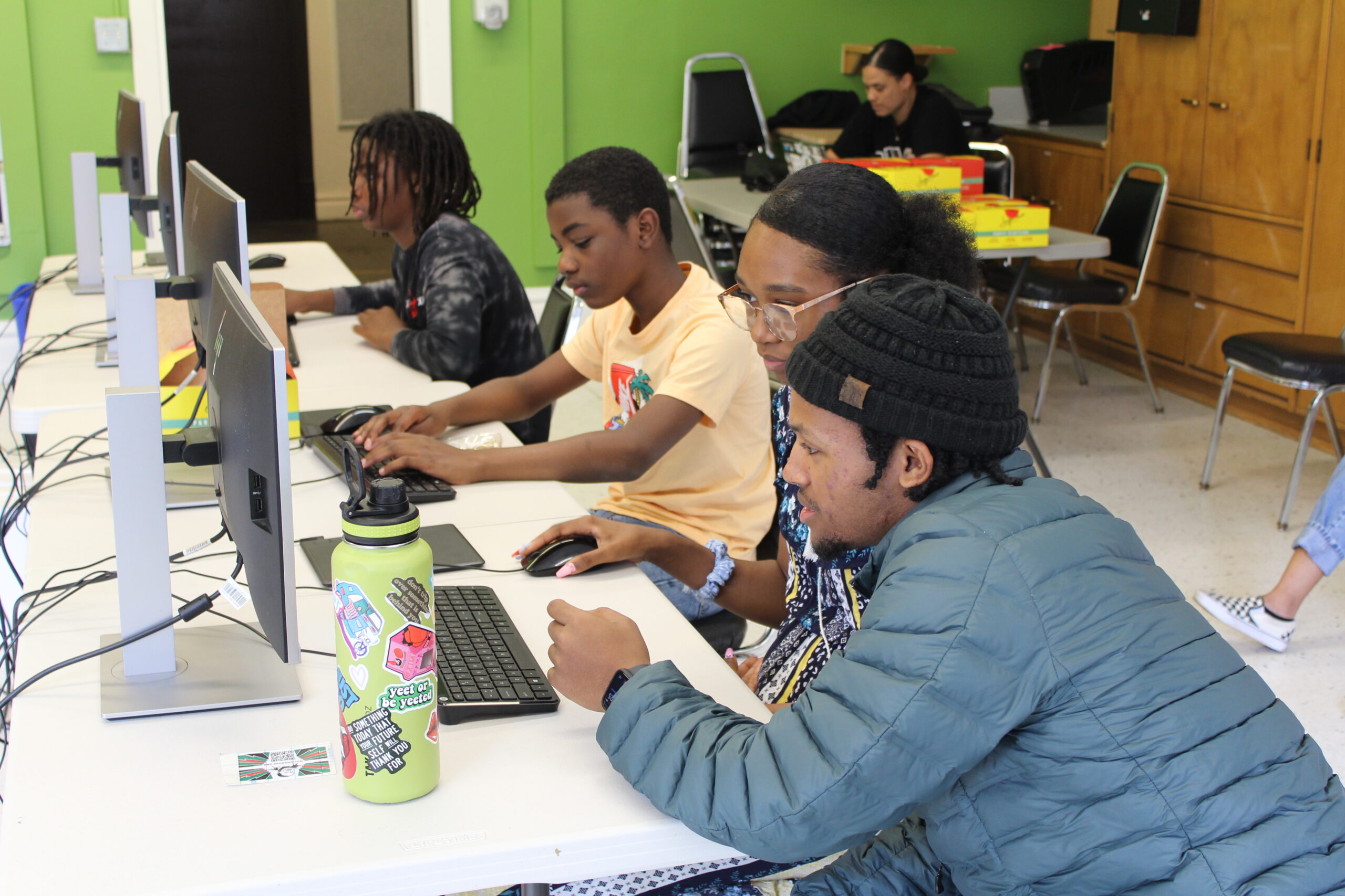 AVELA mentor helping a student at a computer.