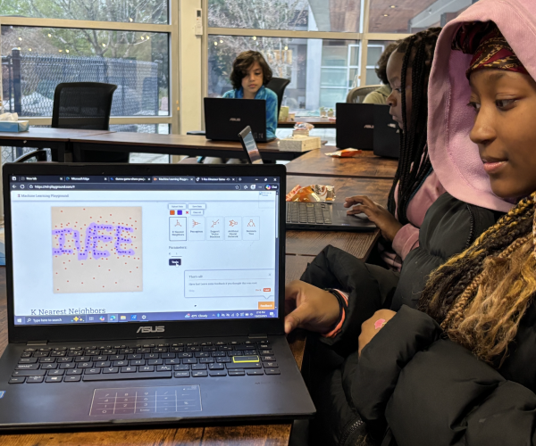 Girl showing a machine learning program spelling "IVEE".